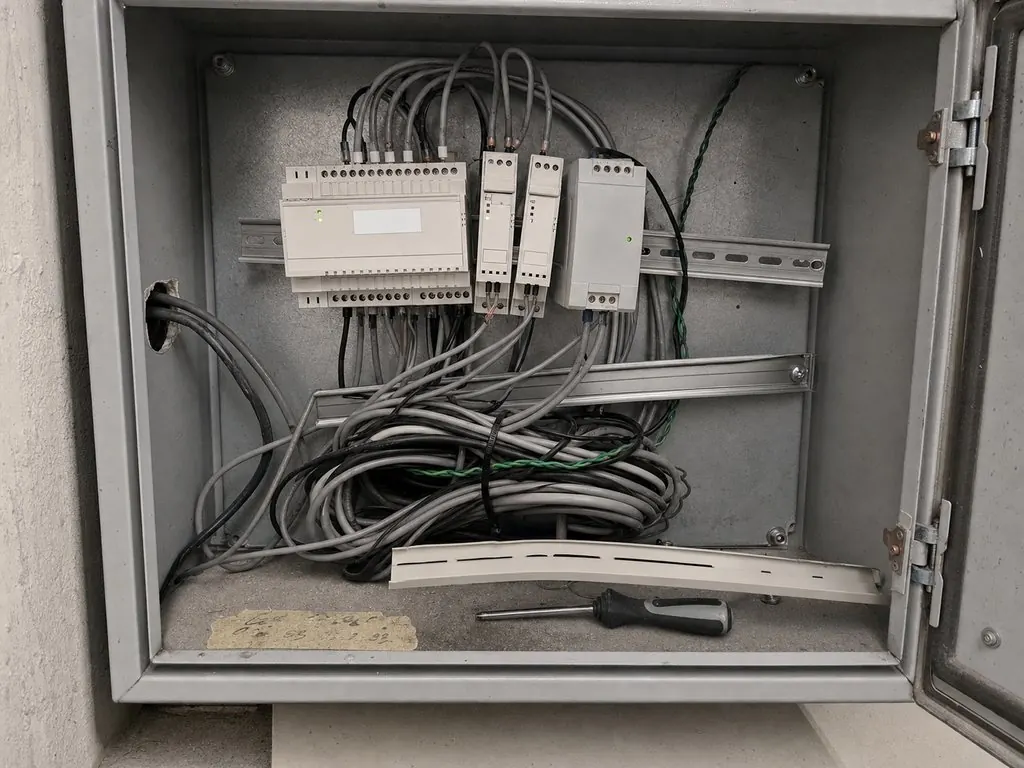 Poorly built control panel with tangled unlabelled cabling and a removed device